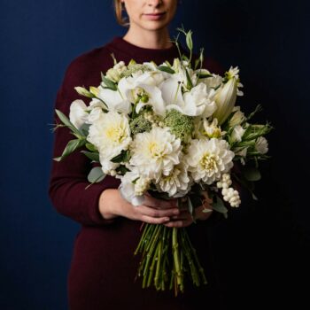 large bouquet of white seasonal flowers including dahlias oriental lillies lisianthus queen anne lace snowberry and foliage