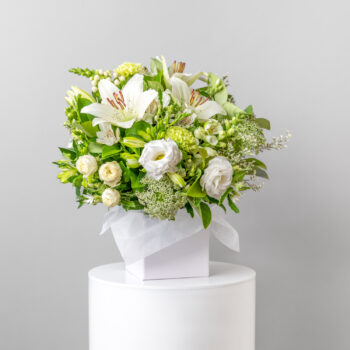 flowers white and green with foliage arranged in a white short flower box