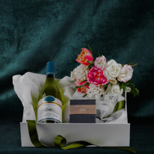 sturdy white box with magnetic lid filled with chardonnay wine bottle box of chocolates and fresh flower posy